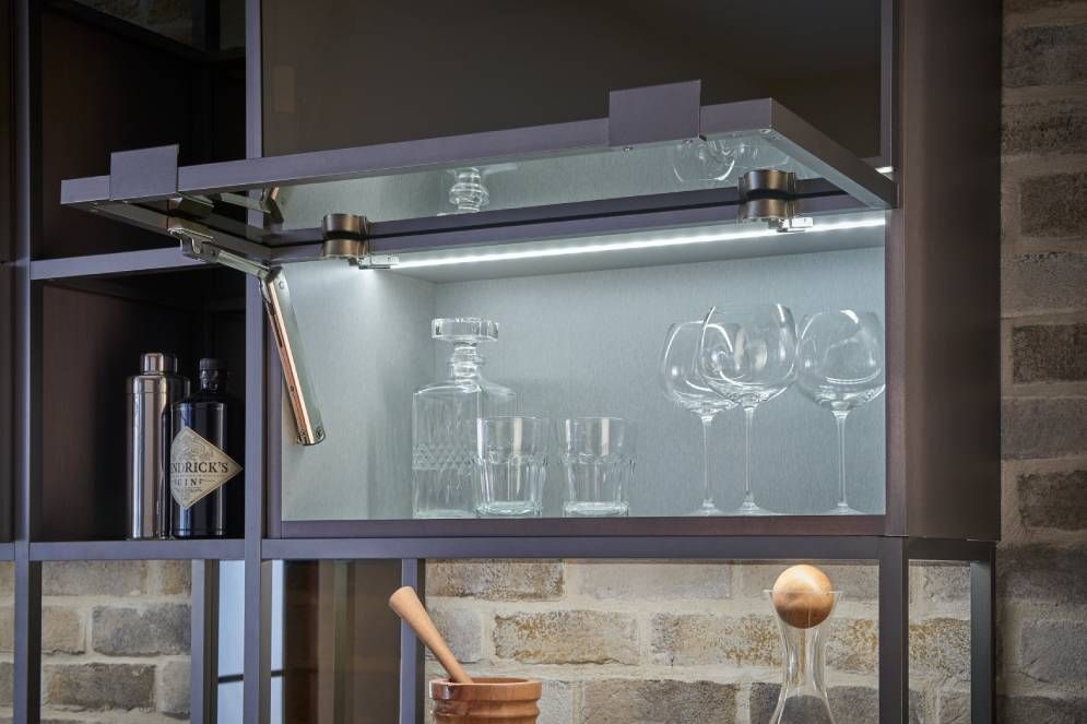 A bar with glasses , bottles , and a mortar and pestle in it.