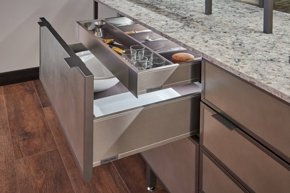 A kitchen drawer with a bowl and glasses in it