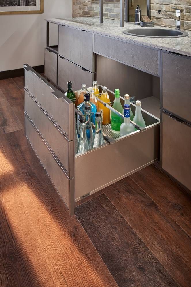 A drawer filled with bottles of liquor in a kitchen.
