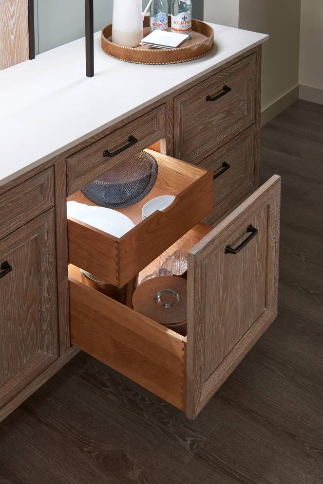 A wooden dresser with a drawer open and a bowl in it.