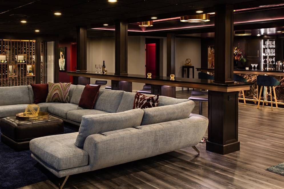A living room with a large sectional couch and a bar.