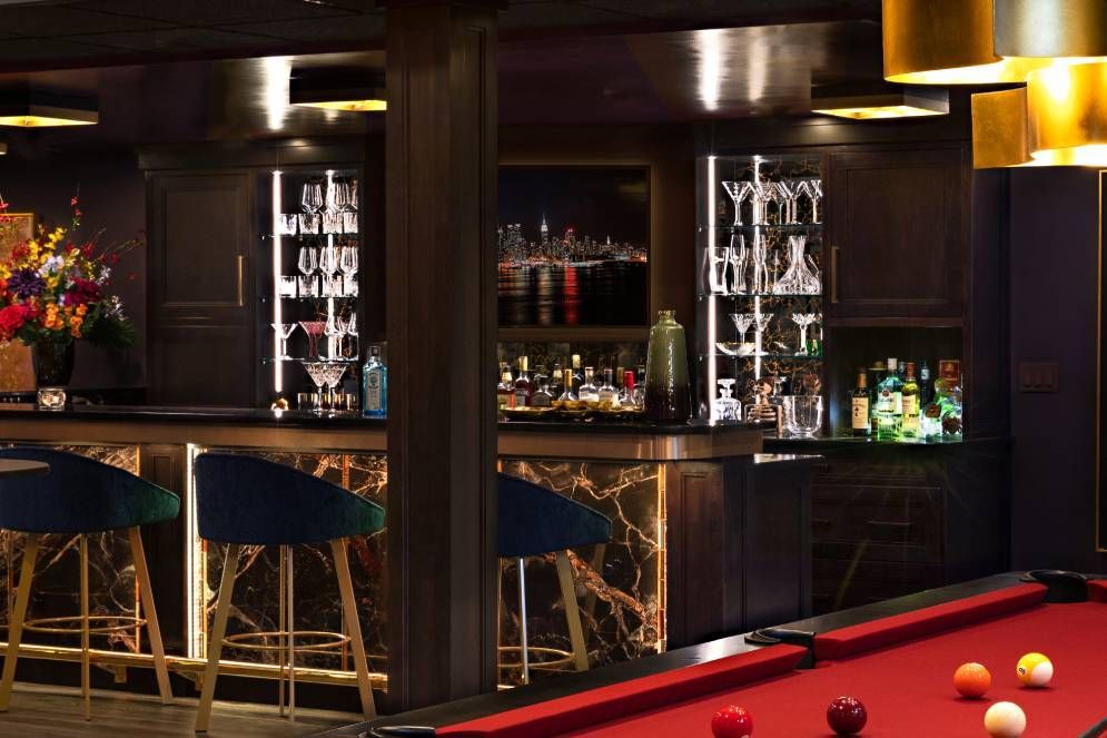 There is a pool table in the middle of a bar.