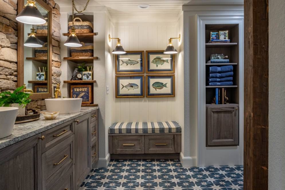 A bathroom with two sinks , a bench and a mirror.