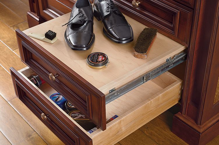 A pair of shoes are sitting on top of a wooden drawer.
