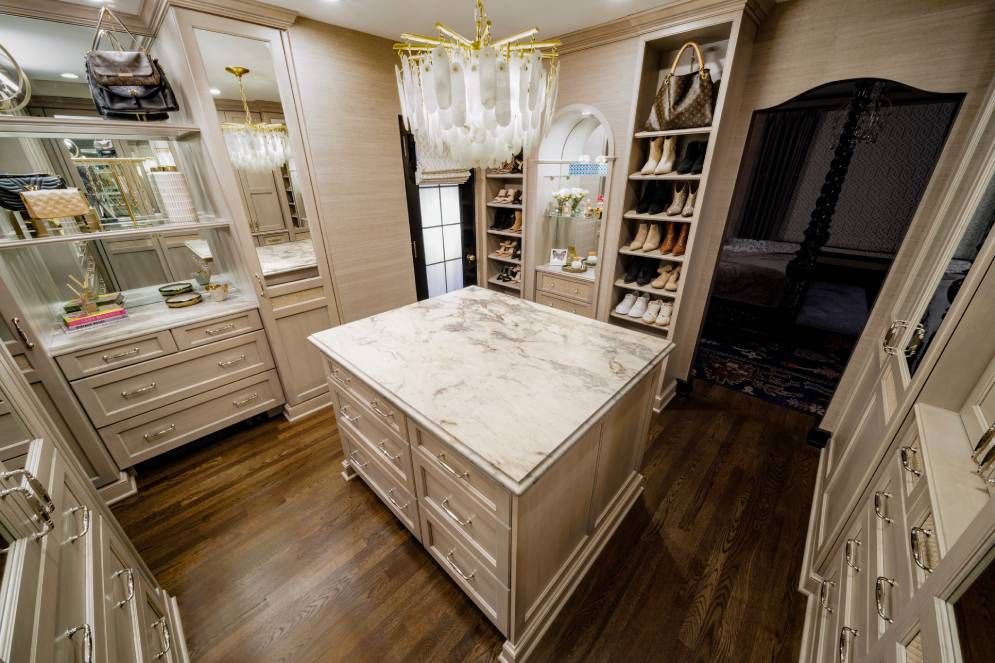 A walk in closet with a large island in the middle.
