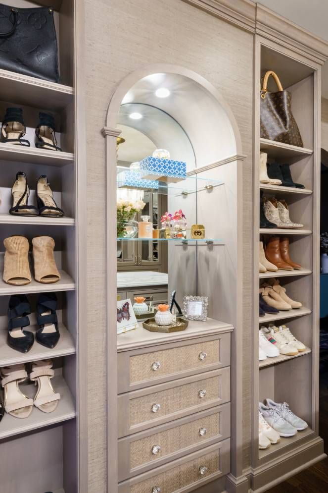 A walk in closet with a dresser and a mirror.