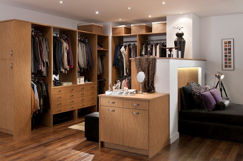 A bedroom with a walk in closet and a dressing table.