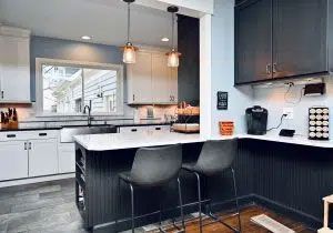 A kitchen with a large island and two bar stools.