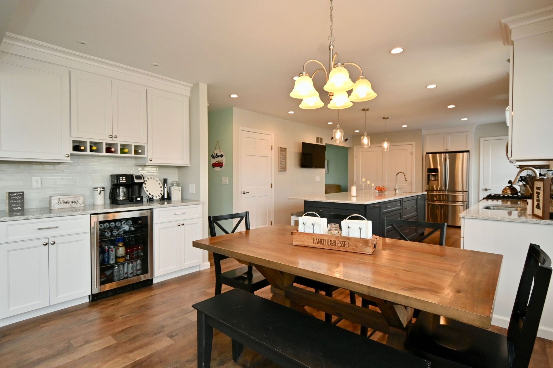A kitchen with a wooden table and chairs and a refrigerator.