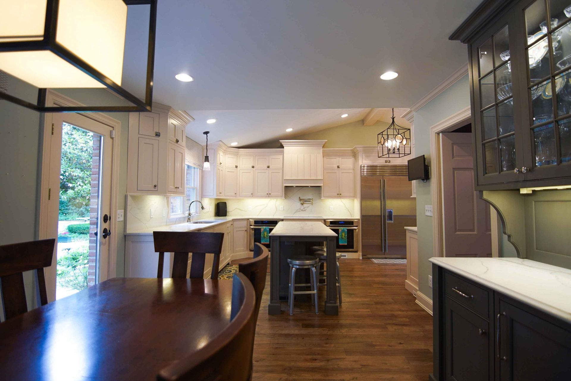 A kitchen with a table and chairs and a large island in the middle.