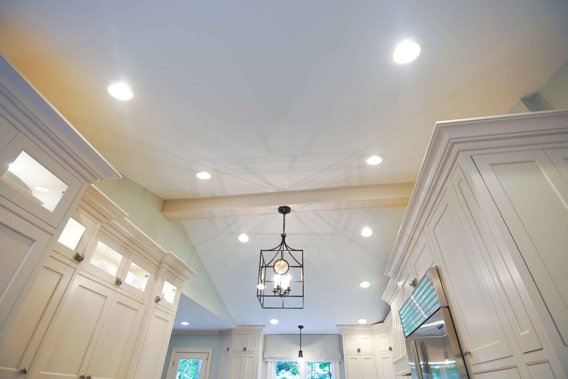 A kitchen with white cabinets and a light fixture hanging from the ceiling.