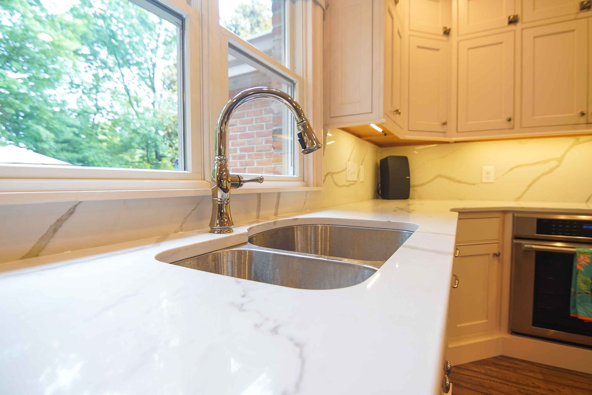A kitchen with a stainless steel sink and a window.