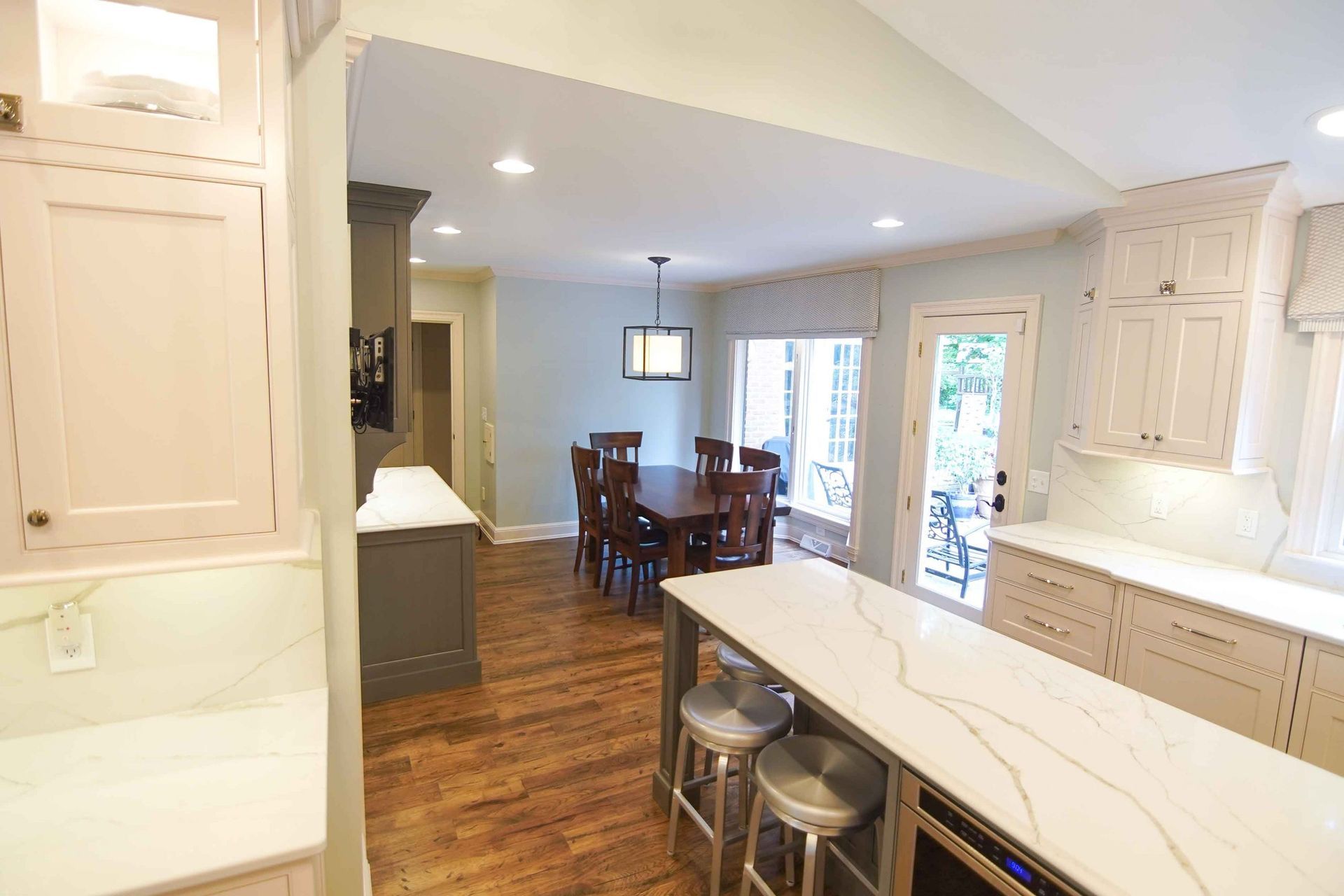A kitchen with a large island and a dining room in the background.