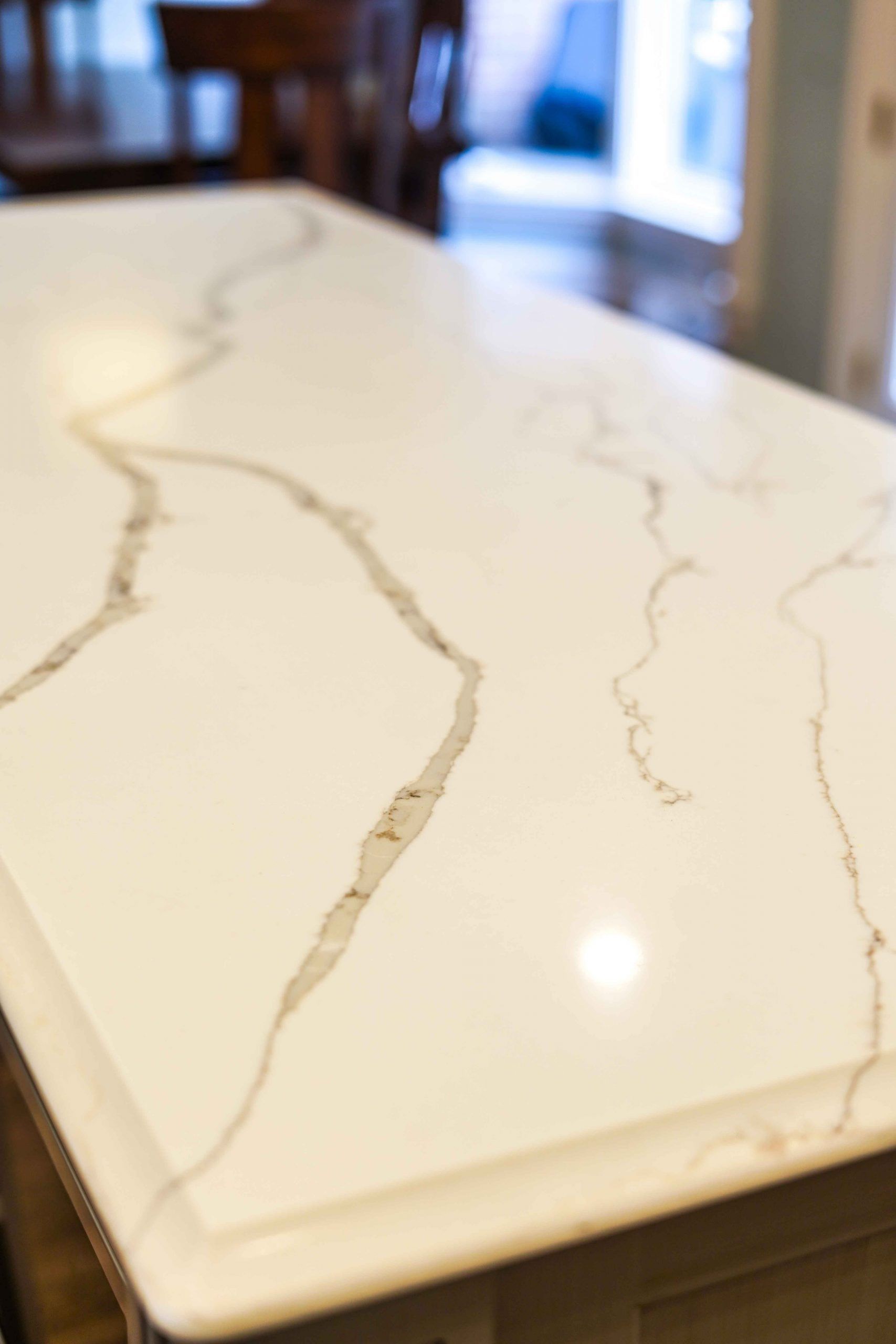 A close up of a white marble counter top in a kitchen.