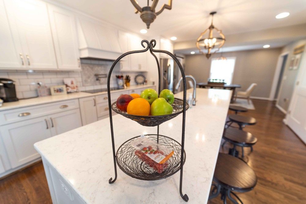 A kitchen counter with a basket of fruit on it.