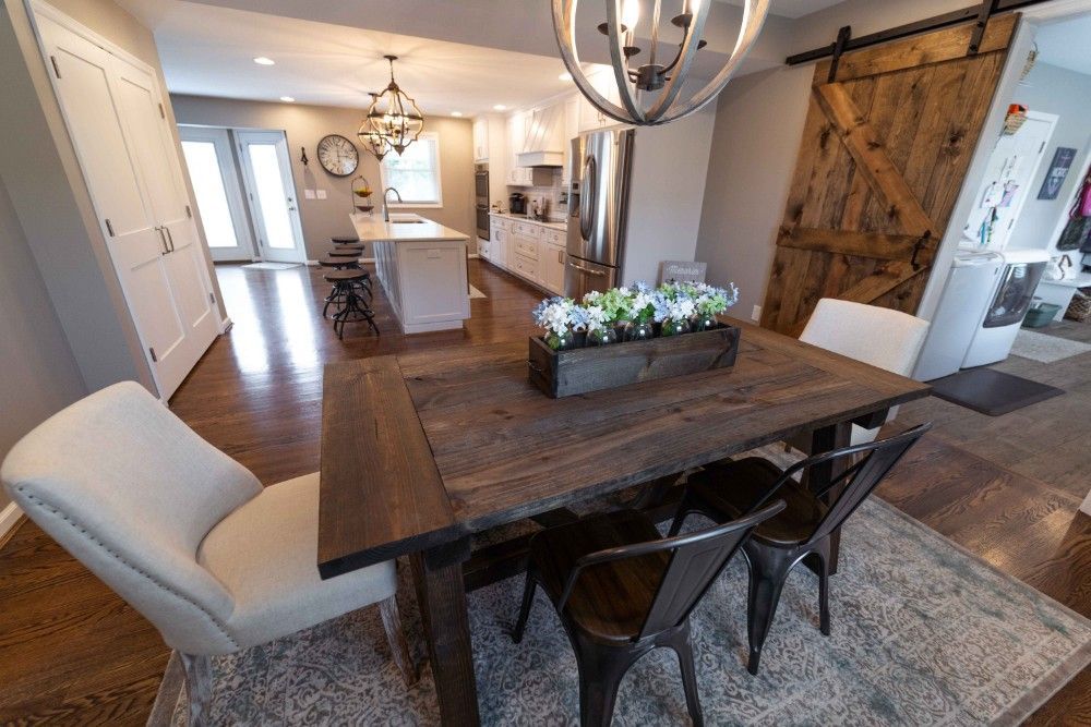 A dining room table and chairs in a kitchen with a sliding barn door.