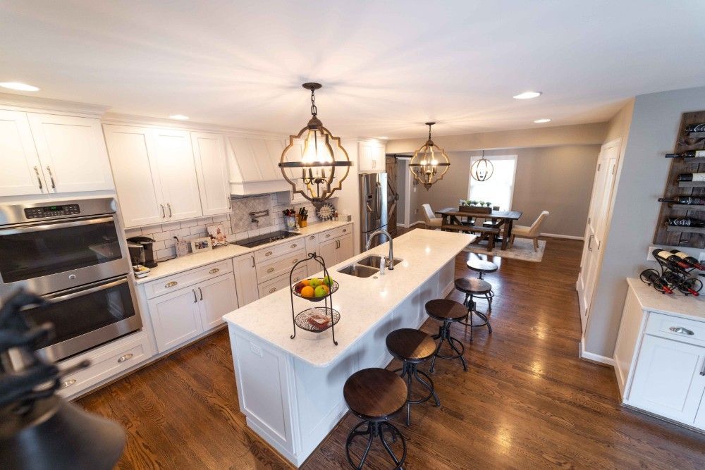 A kitchen with white cabinets and a large island in the middle.