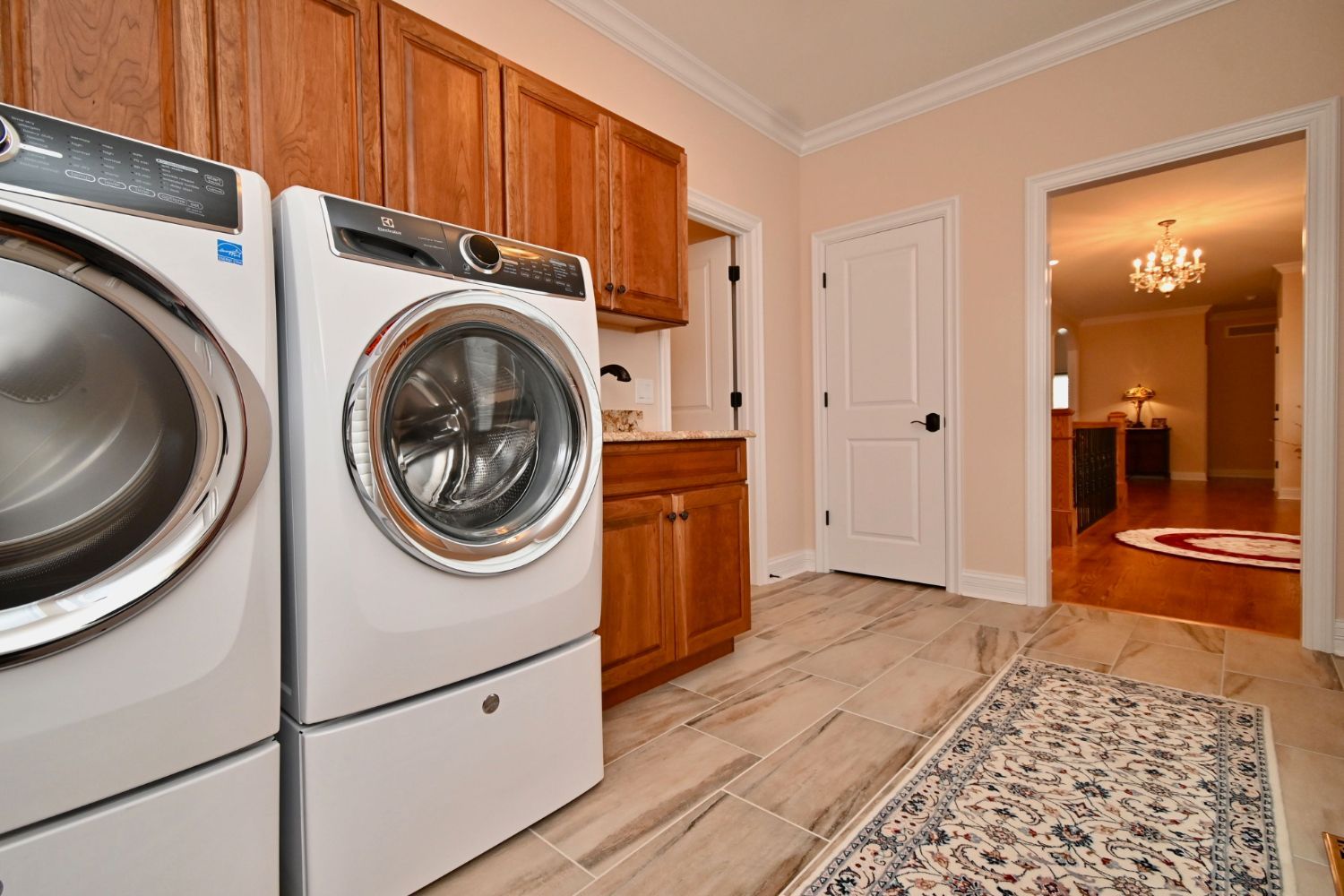 A laundry room with a washer and dryer and a rug.