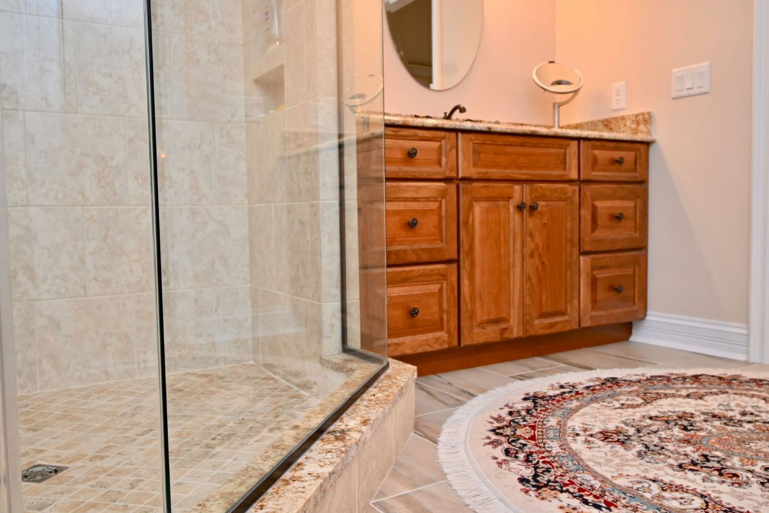 A bathroom with a sink , mirror , and walk in shower.