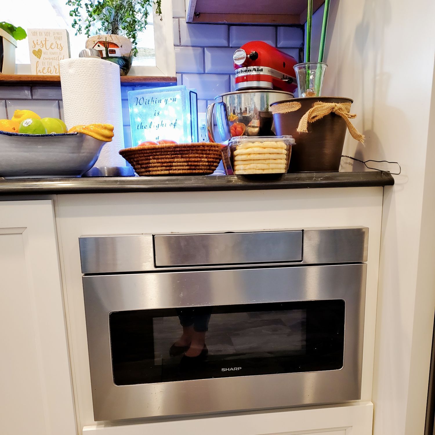 A kitchen counter with a stainless steel microwave oven