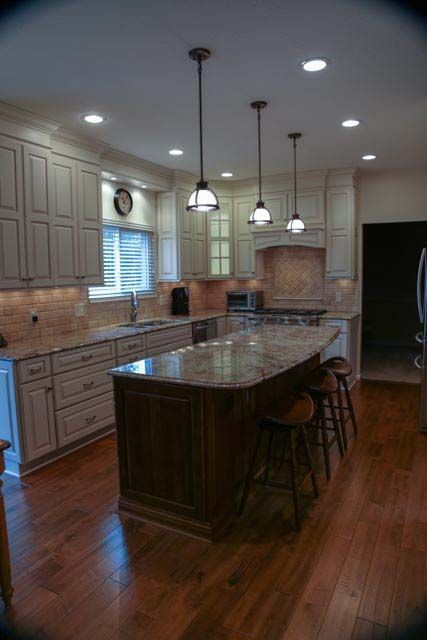 A kitchen with white cabinets and a large island