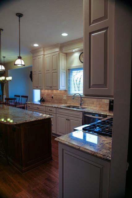 A kitchen with white cabinets and granite counter tops