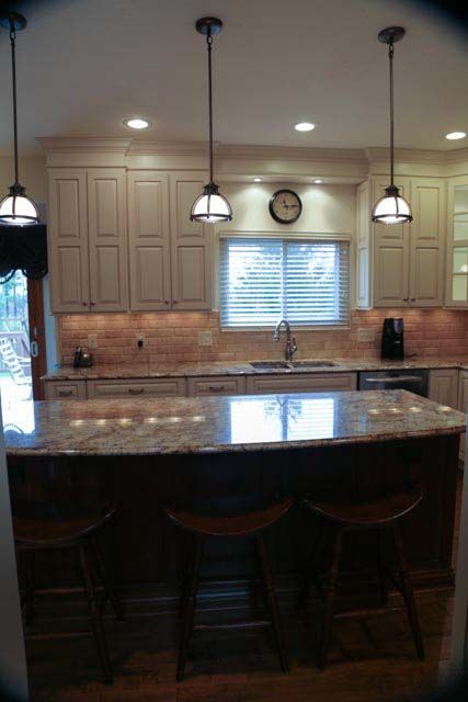 A kitchen with white cabinets and granite counter tops
