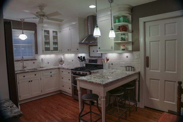 A kitchen with white cabinets and granite counter tops