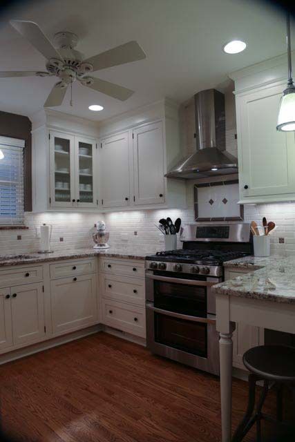 A kitchen with white cabinets and stainless steel appliances