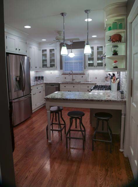 A kitchen with a table and stools in it