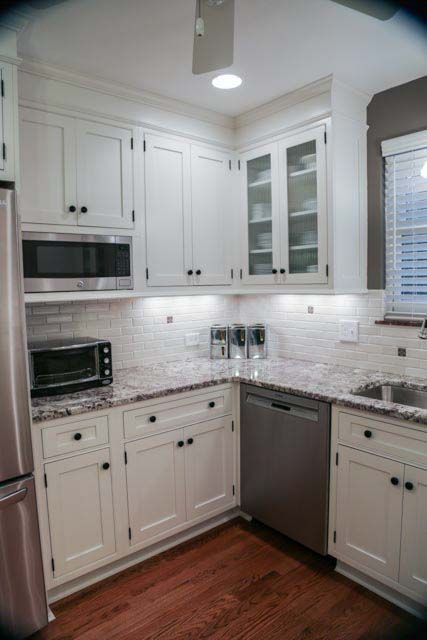 A kitchen with white cabinets and stainless steel appliances