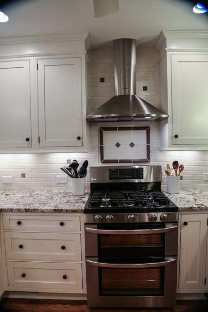 A kitchen with stainless steel appliances and white cabinets.
