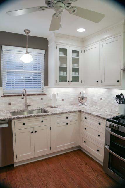 A kitchen with white cabinets and a ceiling fan