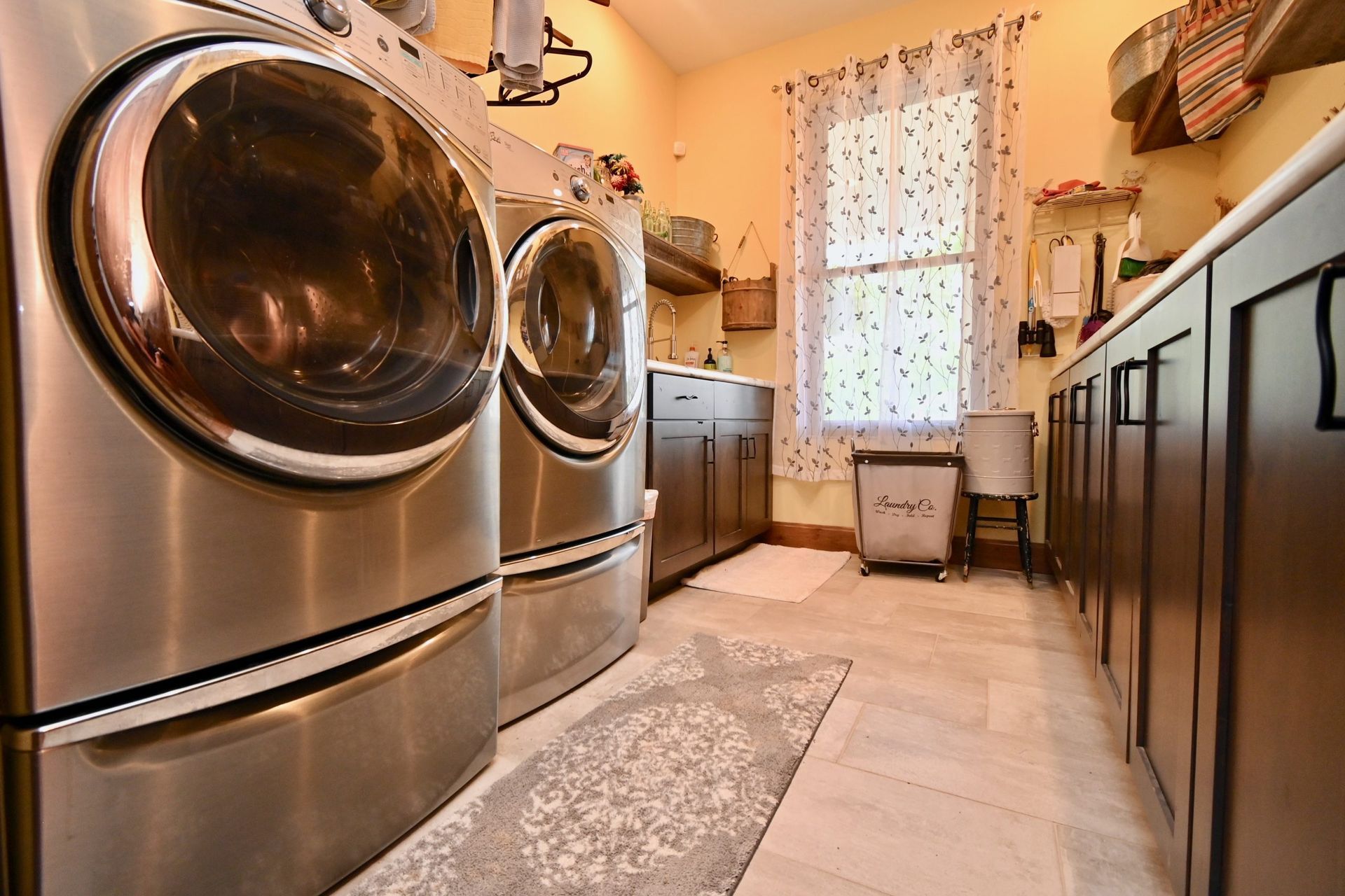 A laundry room with stainless steel washers and dryers.