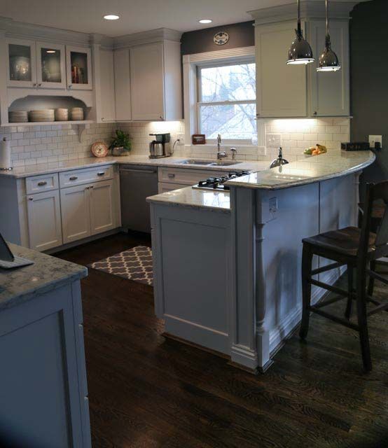 A kitchen with white cabinets and a large island in the middle