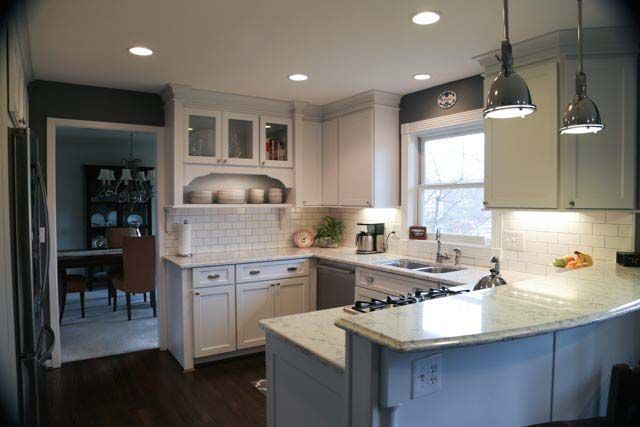 A kitchen with white cabinets , granite counter tops , a sink and a stove.