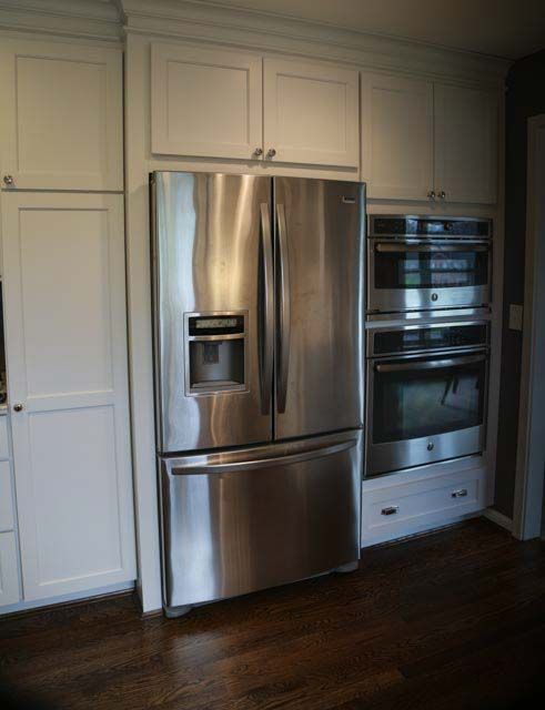 A kitchen with stainless steel appliances and white cabinets