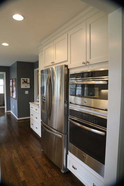 A kitchen with stainless steel appliances and white cabinets