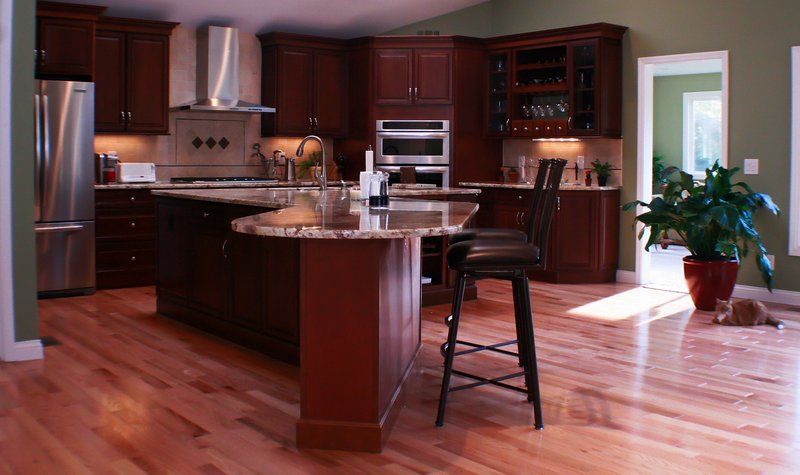 A kitchen with hardwood floors and stainless steel appliances