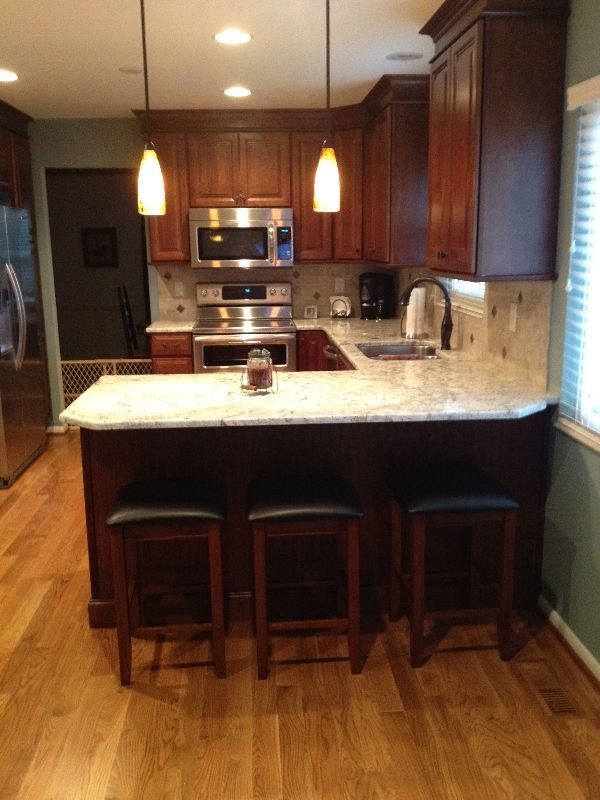 A kitchen with wooden cabinets stainless steel appliances and granite counter tops