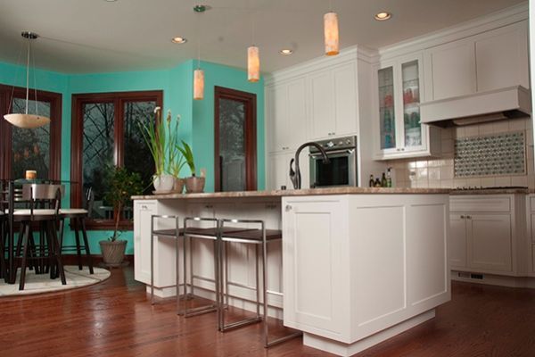 A kitchen with white cabinets and a large island in the middle