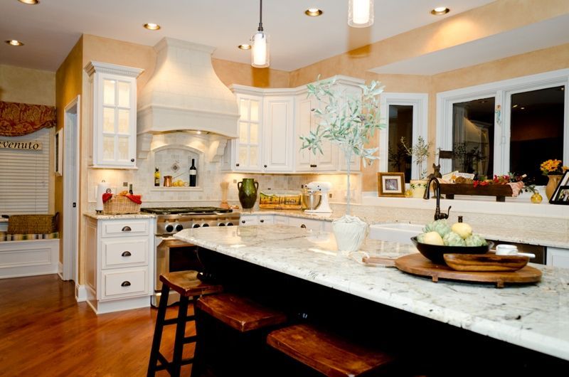 A kitchen with white cabinets and a large island