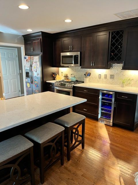 A kitchen with brown cabinets and white counter tops