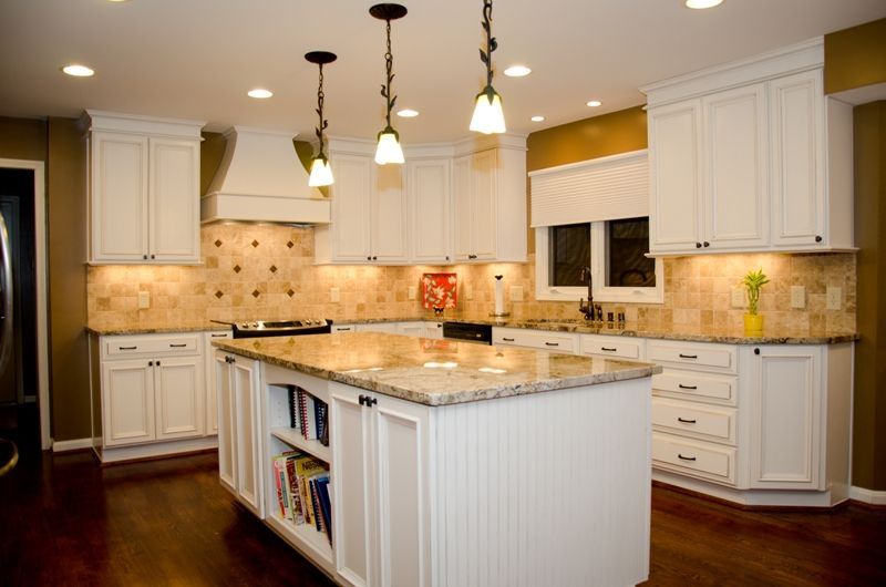 A kitchen with white cabinets and granite counter tops