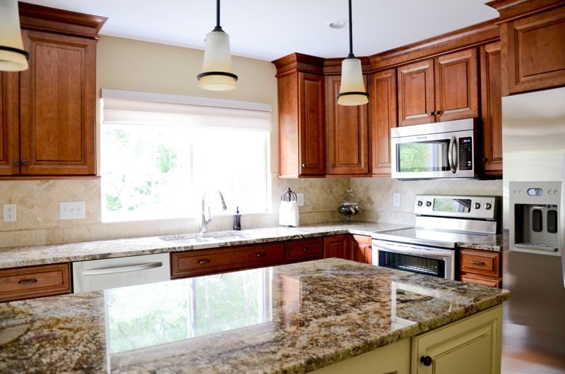 A kitchen with granite counter tops and wooden cabinets