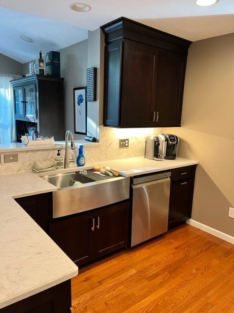 A kitchen with stainless steel appliances and black cabinets