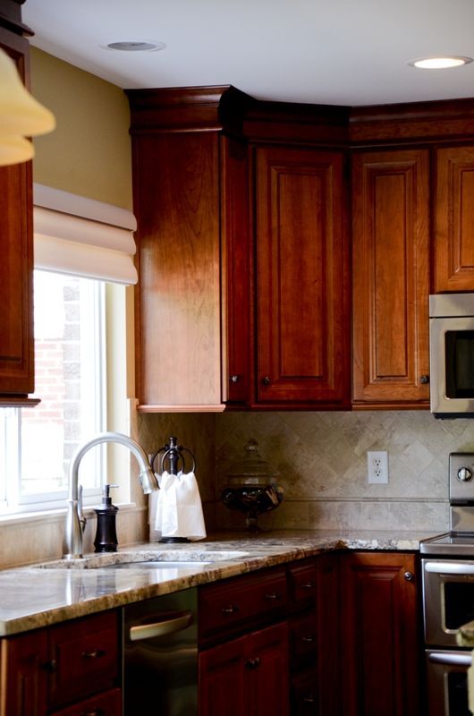 A kitchen with wooden cabinets and granite counter tops