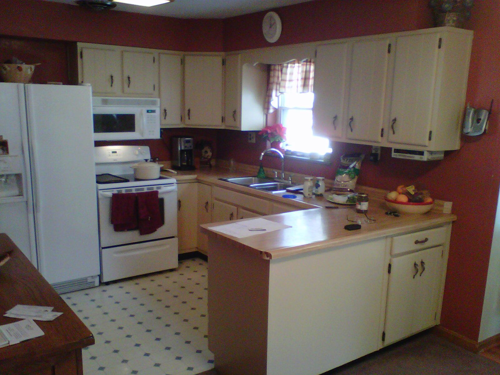 A kitchen with white cabinets and a white refrigerator