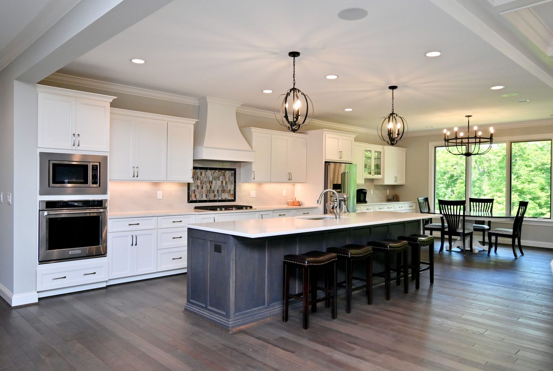A large kitchen with white cabinets and a large island