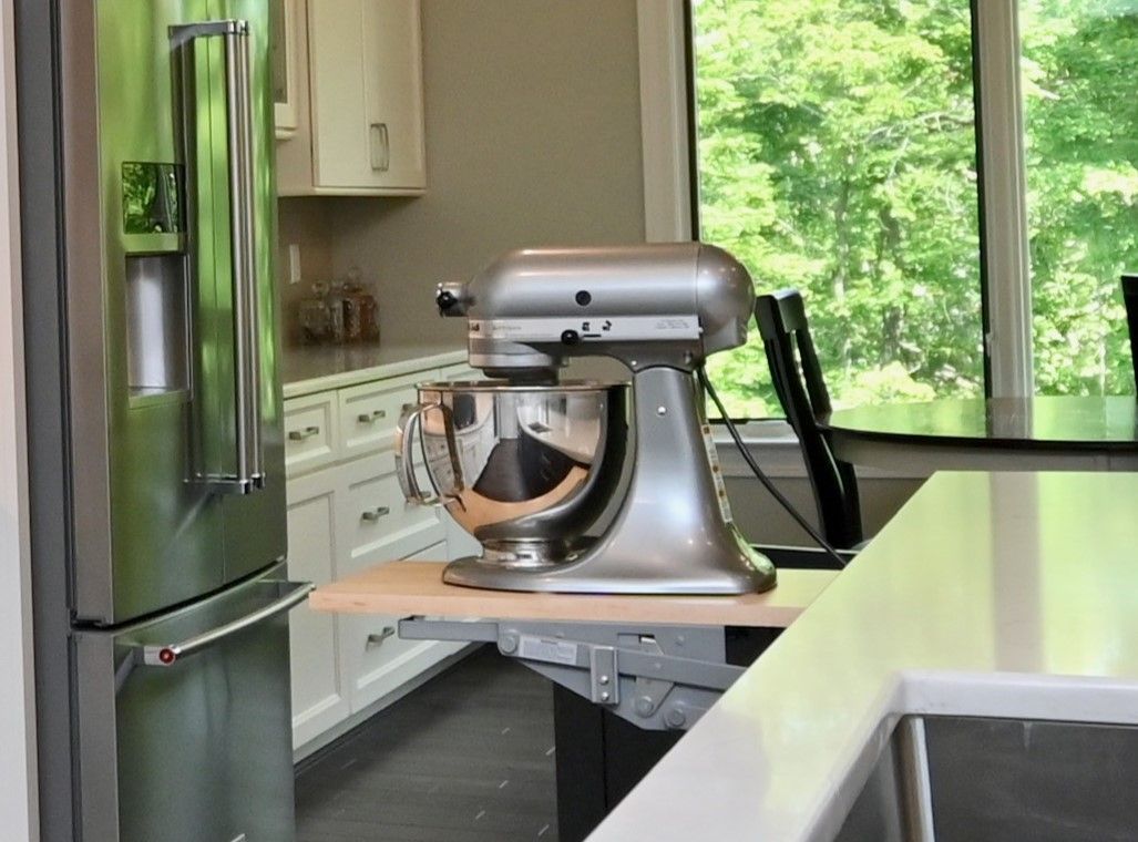 A kitchen mixer is sitting on a counter in a kitchen